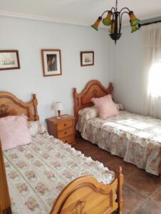 habitacion con dos camas y cojin rosa inmobicasasbullas
